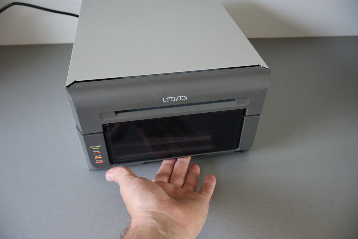 Hand greift unter den Citizen CX Drucker zum blauen Hebel