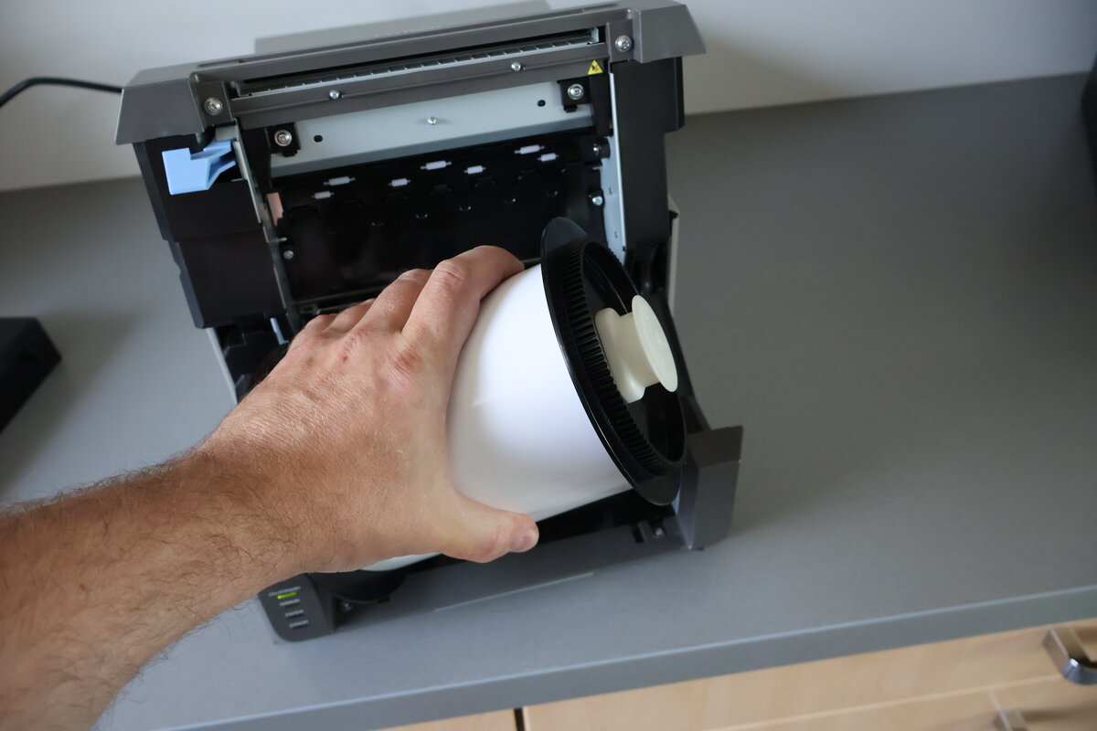 Leere Papierrolle wird aus dem Citizen CX Drucker entnommen