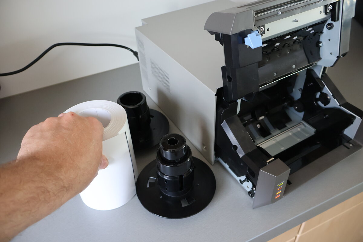 Schwarze Flansche mit Zahnrädern werden von der alten Papierrolle abgezogen