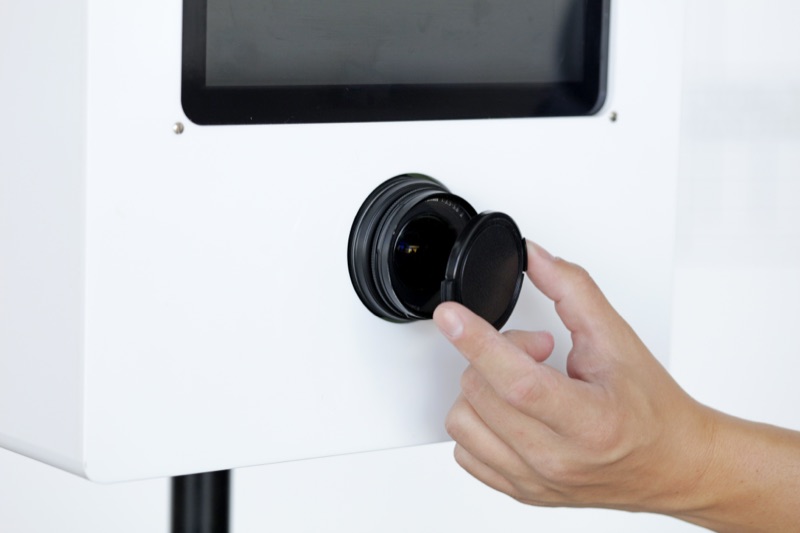 Objektivdeckel der Spiegelreflexkamera wird abgenommen