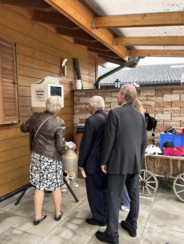 Hochzeitsgäste nutzen die SmileCube Fotobox auf einer Scheunenhochzeit