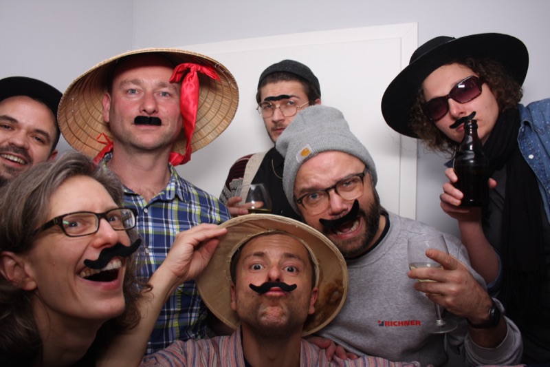Gruppe mit Schnurrbärten und Hüten an der SmileCube Fotobox