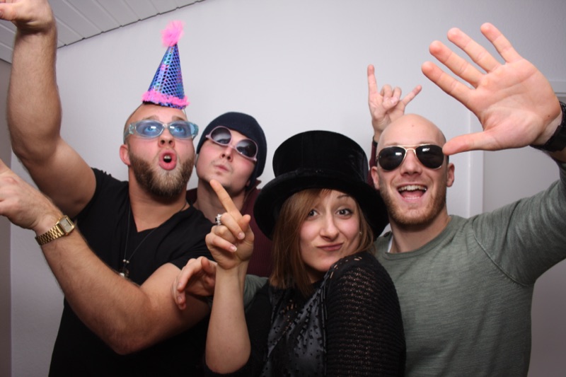 Freunde mit Partyhüten und Sonnenbrillen an der SmileCube Fotobox